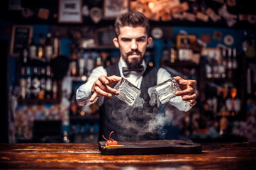 Young Female bartender demonstrates the process of making a cocktail in the bar