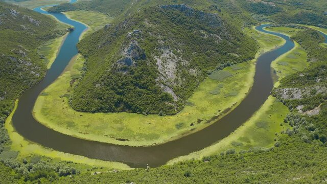 Aerial view of the the old Rijeka Crnojevica river, surrounded by picturesque green trees