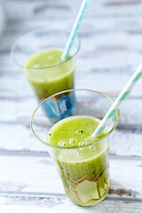 Green smoothie topped with chia seeds on bright wooden background. Close up. 