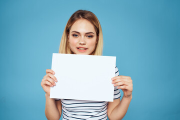 Fototapeta premium Woman holding sheet of paper striped T-shirt Copy Space cropped view blue background