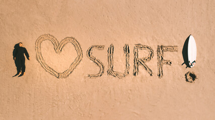 I love surf. Top view of a surfer with a surfboard lying on the sand on the beach. Water sports. Surfing