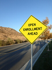 Yellow diamond road sign announcing open enrollment ahead