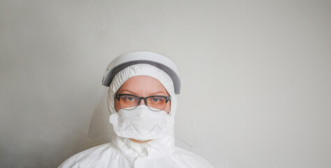 the doctor is a middle-aged woman in rotective suit and mask