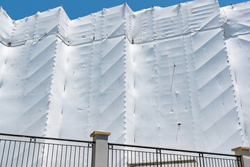 AUCKLAND, NEW ZEALAND - Dec 05, 2019: Building with scaffolding covered with white scaffold mesh