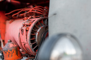 Closeup of red tractor fuel injectors four cylinder diesel engine details on sharp focus in rural...