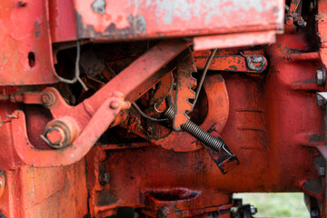 Closeup of hydraulic mechanism spring and wiring on old rusty russian tractor with grease oil autumn harvest machinery