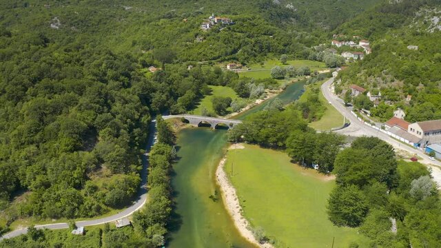 Aerial view of the the old Rijeka Crnojevica river, surrounded by picturesque green trees