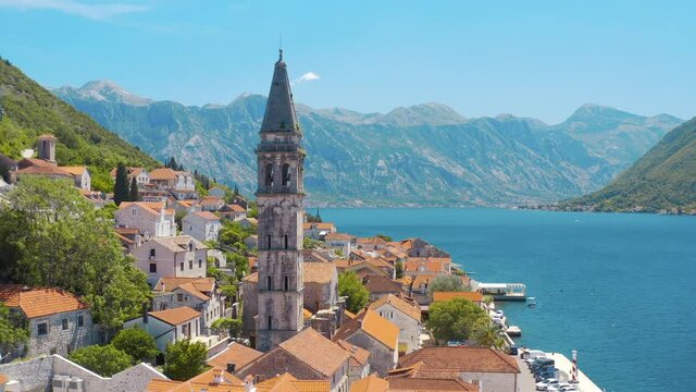 Drone flying over the the St. Nicholas Church and cityscape in Perast, Montenegro. Amazing blue sea and magnificent mountains