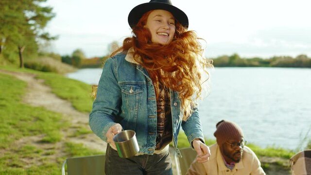 At sunlight hipster friends met eath other having party in nature. Four young people hug smiling with dog. Vacation tourism adventure outdoors. Slow motion