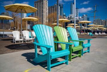 blue and green muskoka chairs in toronto with yellow umbrellas