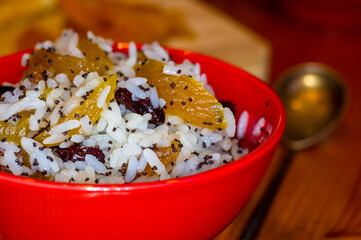 handmade preparation of treats for traditional Orthodox Christmas - rice pudding with fruits, cranberries, honey, nuts, Church candles