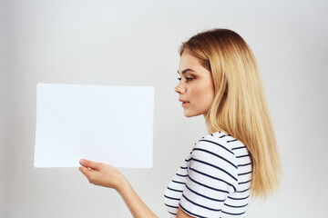 Naklejka premium woman holding a sheet of paper in her hands lifestyle striped t-shirt cropped view Copy Space