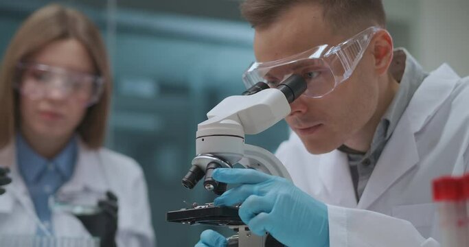forensic expert laboratory, man and woman crime specialists are working together, looking for evidences