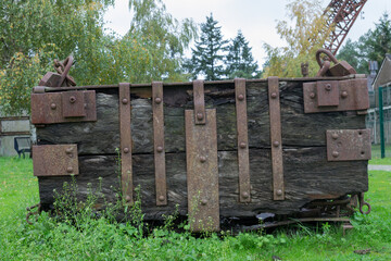 Abandoned wooden iron-ore cart with vertical metal strapping bands.