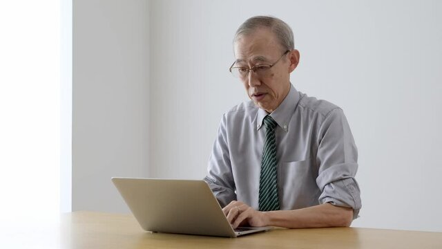 パソコンでビデオ会議をするシニア男性