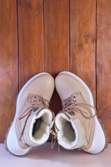 Two winter or autumn boots on a brown wooden background