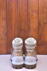 Two winter or autumn boots on a brown wooden background