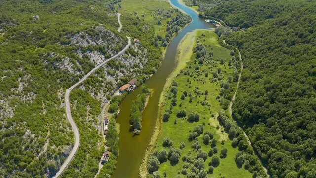 Aerial view of the the old Rijeka Crnojevica river, surrounded by picturesque green trees