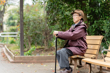 Fototapeta premium 公園でベンチに座るシニア男性