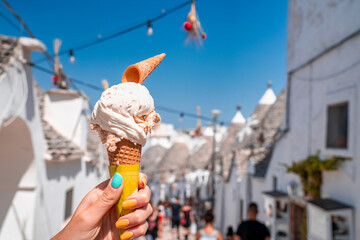 Close up view of the Italian ice cream - gelato with traditional trulli houses in Arbelobello on...
