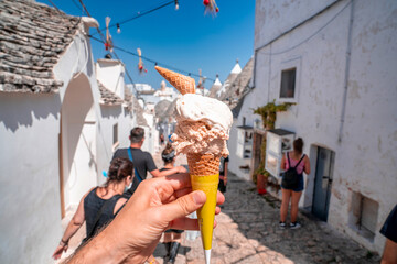 Close up view of the Italian ice cream - gelato with traditional trulli houses in Arbelobello on...