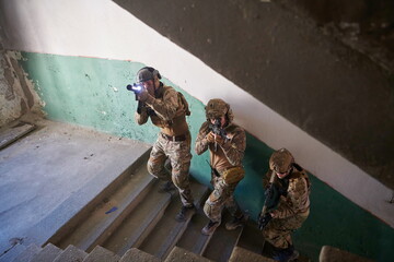 modern warfare soldiers ascent stairs in combat - obrazy, fototapety, plakaty