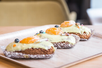 three eclairs with custard in a bakery
