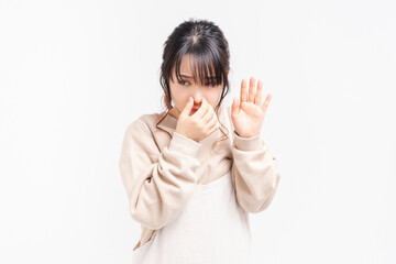鼻をつまむ若い女性