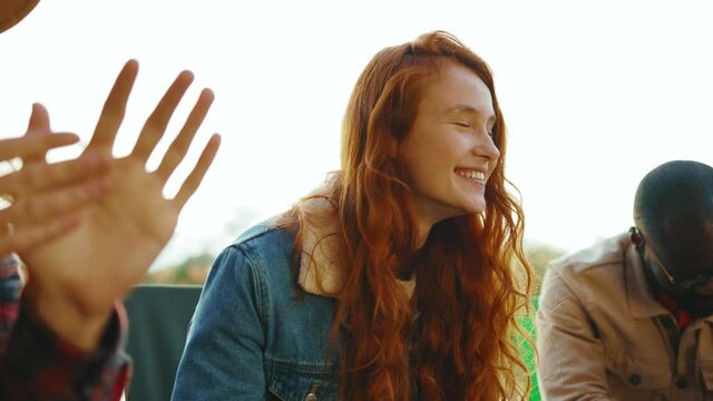 Portrait friends sitting near campfire in nature. Young people talk plays with dog smiling feel happy. Vacation tourism adventure outdoors. Slow motion