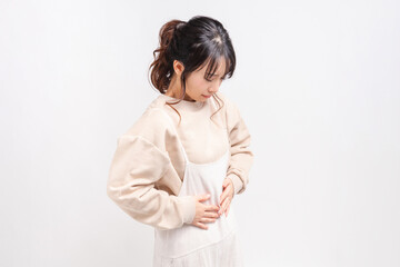 お腹に手を当てる若い女性