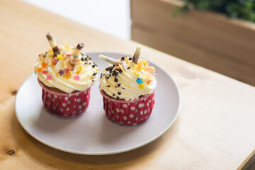 cupcakes with custard and confectionery powder in the white plate on the bakery