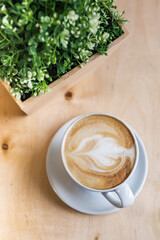 morning cup of latte in a white bowl on a wooden table on the coffeeshop