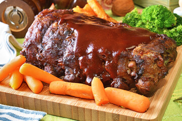Grilled and smoked pork ribs with barbeque sauce on a wooden board. 