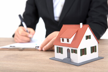 Real estate related practitioners working on a table with a small house model