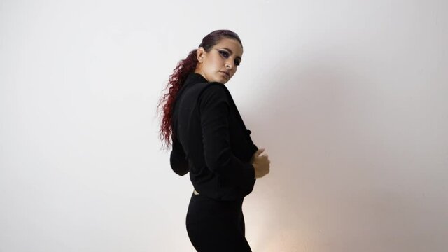 Young girl doing various poses for a photo shoot dressed in black with a jacket and red hair. Flash shutting