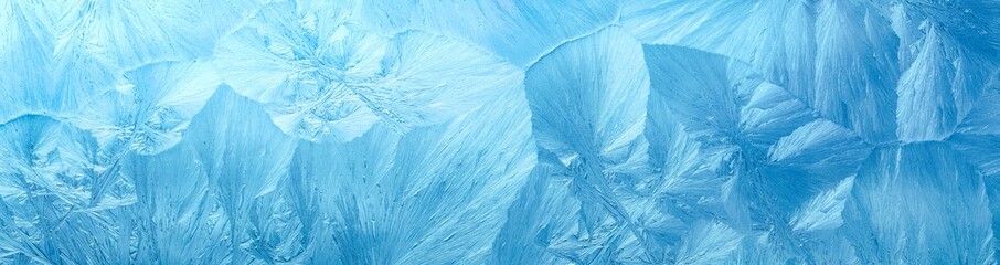 Wintry background with winter frost covered window with a pattern of ice crystals.