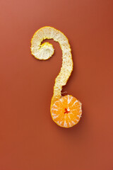 Peeled orange on orange background question mark shape