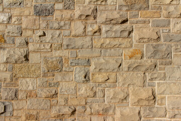 Full frame abstract background of an attractive tan brown natural limestone block wall in ashlar...