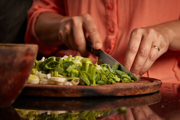 Closeup shot of a woman chopping green onion