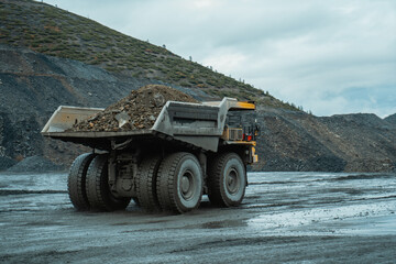 The dump truck is going through a gold mining career. The view from behind.
