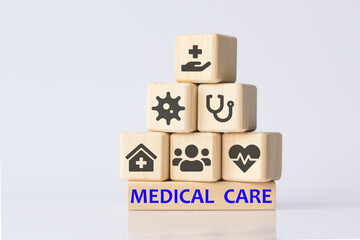 icons on wooden toy blocks stacked in pyramid shape. Concepts a physical examination for health care and medical insurance. The concept of insurance. MEDICAL CARE