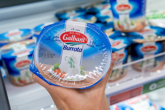 Tyumen, Russia-November 07, 2020: Man hand holding a bag of Galbani buratta in supermarket
