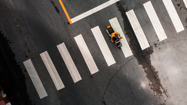 Aerial View Of Abstract Crosswalk On Asphalt Road. Blurry Motorcycle Riding Pass Cross Way.