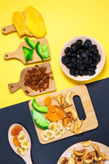dried fruits on a colored background Flat lay. mango, raisins, papaya, bananas, dried apricots. Healthy vegetarian food. vertical photo