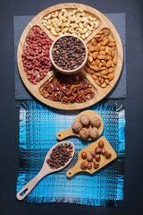 wooden bowl with mixed nuts. Healthy food and snack. Walnut, almonds, hazelnut and cashews. vertical photo