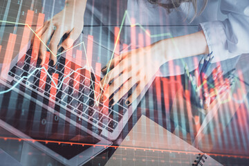 Double exposure of woman hands typing on computer and forex chart hologram drawing. Stock market...