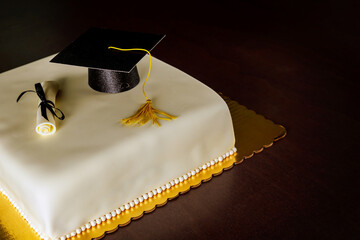 Graduation party cake with hat and diploma decoration.