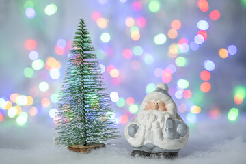 Christmas greeting card with decorative cute Santa Claus and fir tree. Bokeh effect on background