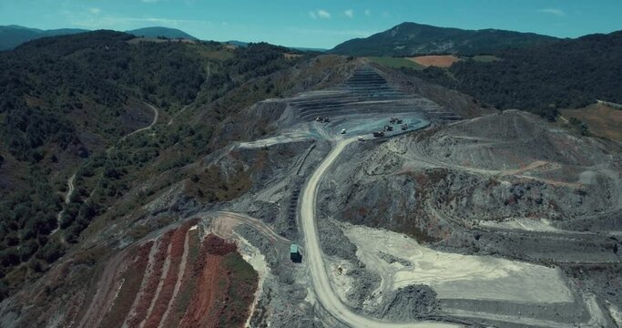 Panorama aerial view shot of the top opencast coal mining, quarrying extractive industry stripping work. Mining Trucks parked in the middle
