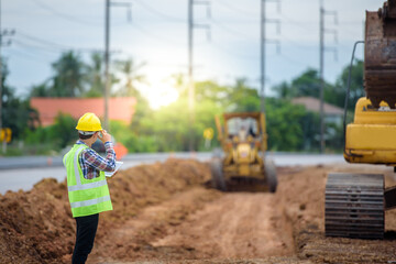 Young Asian engineers supervise road construction and inspect road construction at construction...